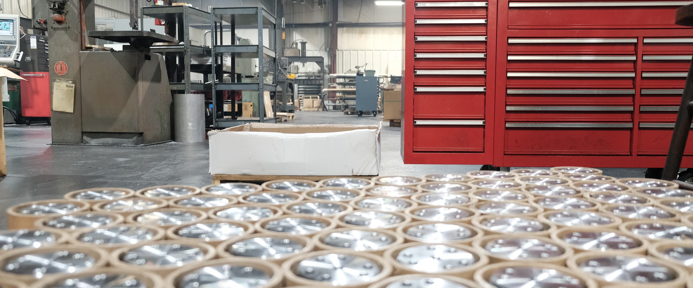 A production run of machined parts, packed in tubes and staged on the ATM shop floor