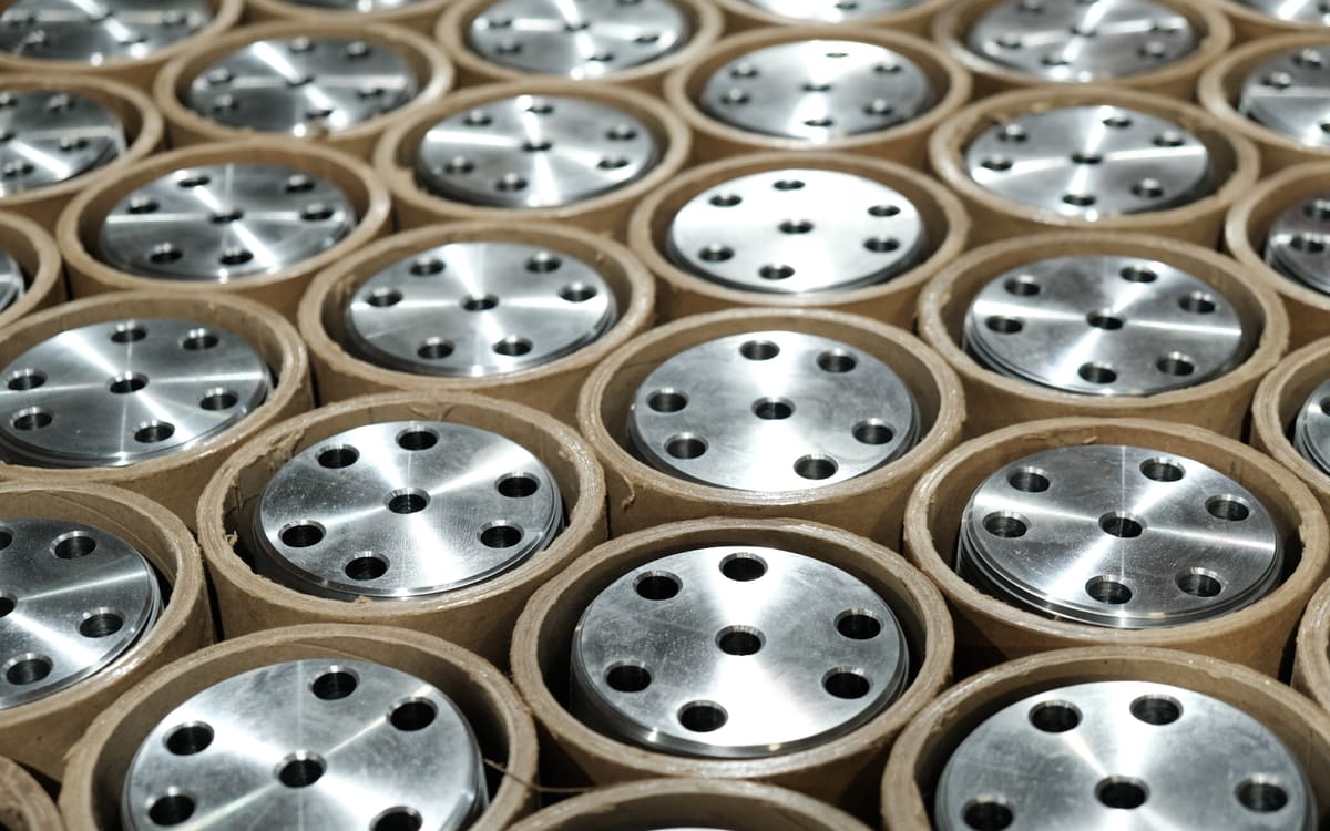 A production run of machined parts, packed in tubes